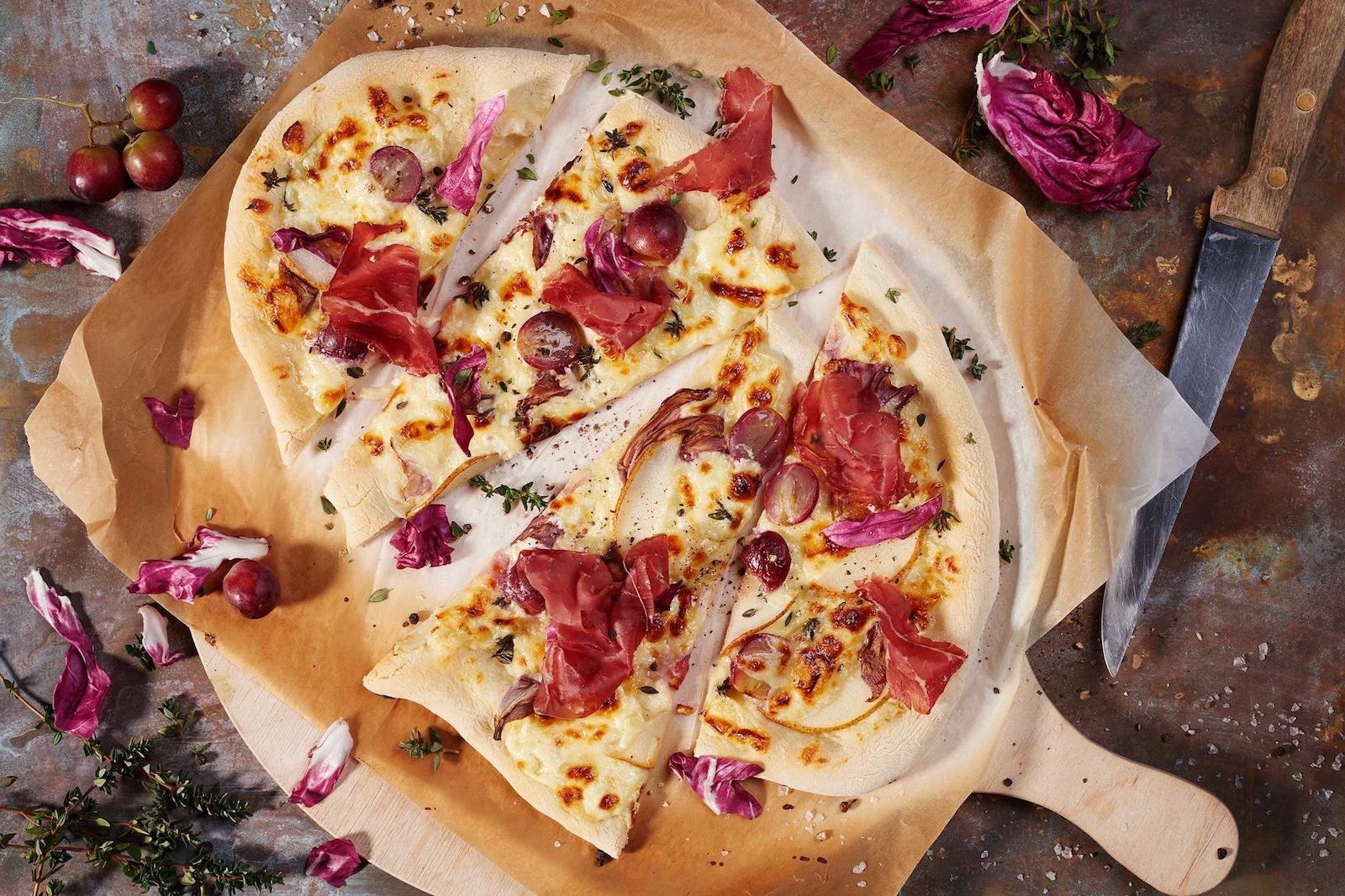 Tarte flambée à la crème aigre, au raisin, au radicchio et à la viande des Grisons